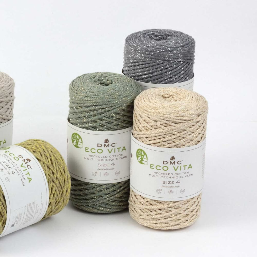 Stacked spools of DMC Eco Vita 4 recycled cotton yarn in pink, green, blue and mustard
